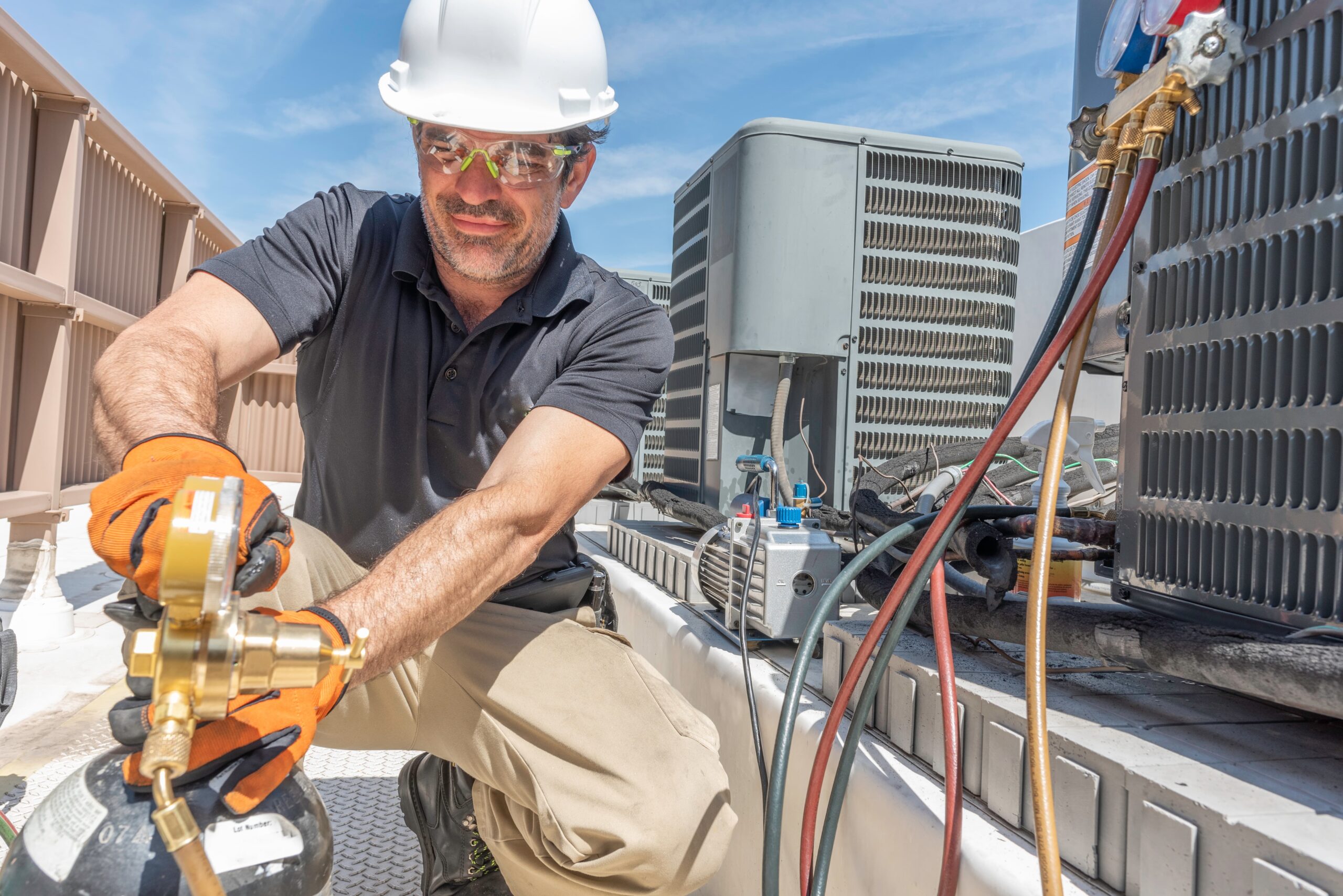 Technician installing a modern HVAC outdoor unit for residential home