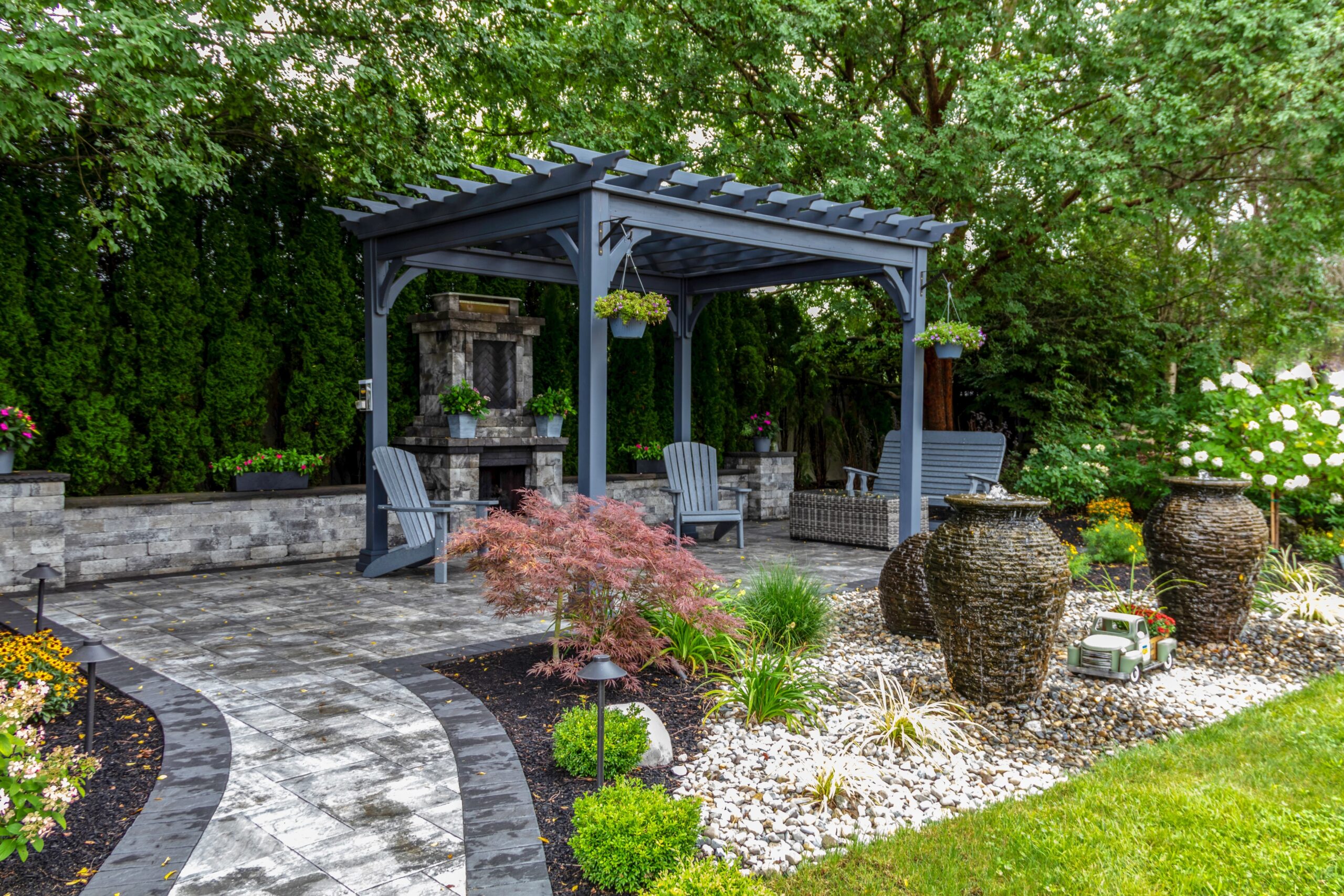 Backyard stone patio with seating area and landscaping